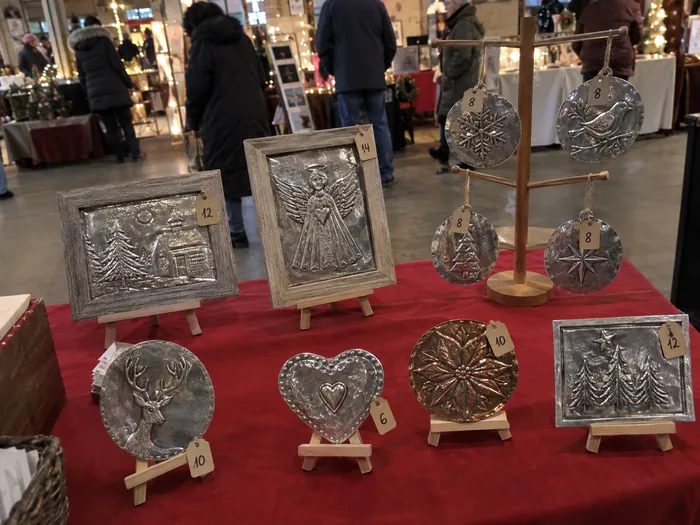 A craft market stall with handmade metal pieces for sale
