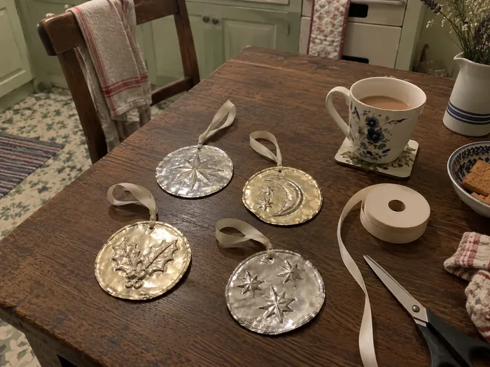 Four handmade metal ornaments on a kitchen table